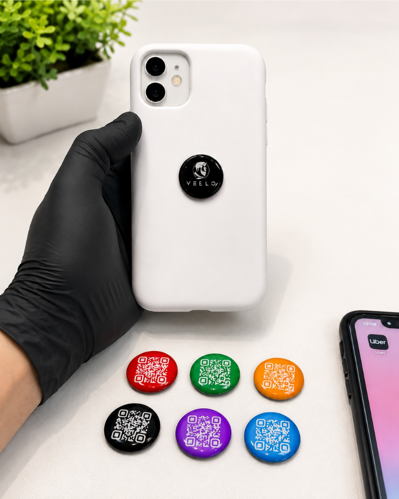 Super Tags NFC coloridas com QR Code coladas em celular e sobre a mesa